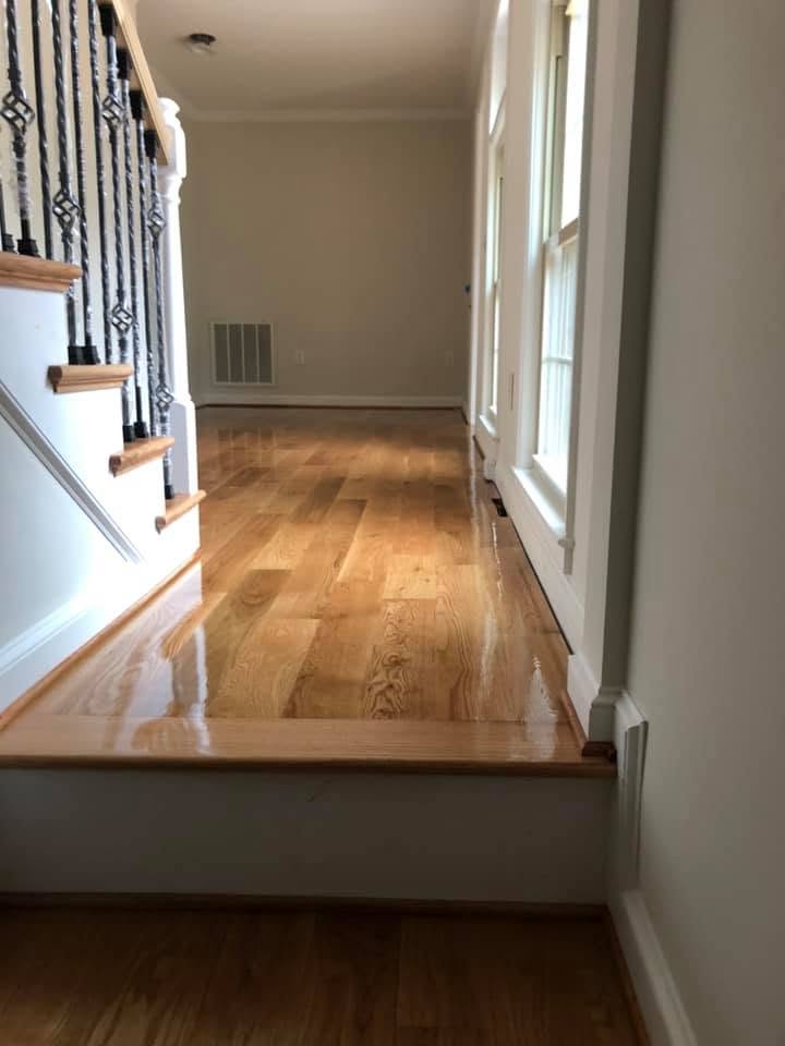 Freshly finished white oak hallway floor with a satin sheen beside a staircase