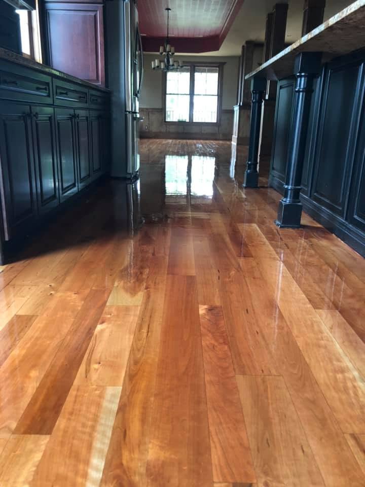High gloss refinished cherry hardwood floors in a kitchen with dark cabinetry